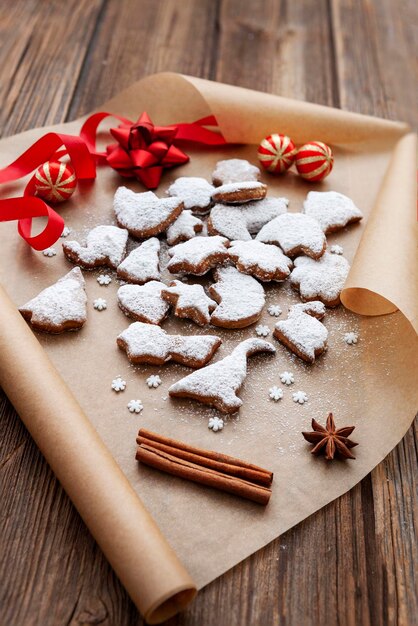 Traditional Christmas homemade cookies gingerbread sprinkled with powdered sugar on wrapping paper