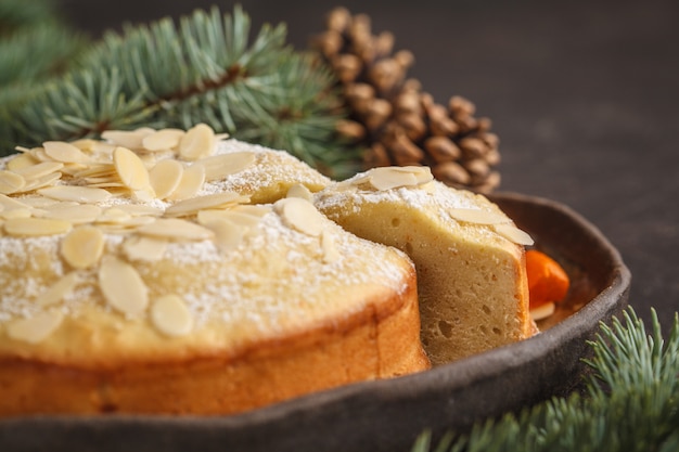 Traditional Christmas (Norwegian) almond pie in Christmas decorations, dark background. 