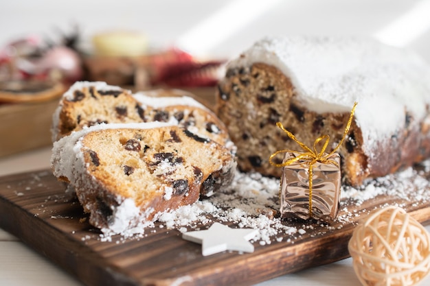 Traditional Christmas stollen made of dried fruits and nuts sprinkled with powdered sugar