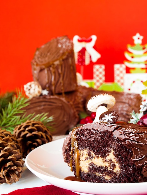 マジパンのキノコで飾られた伝統的なクリスマスのユールログケーキ。