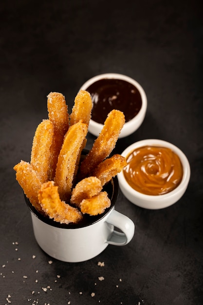 Traditional churros with sugar dulce de leche and chocolate sauce