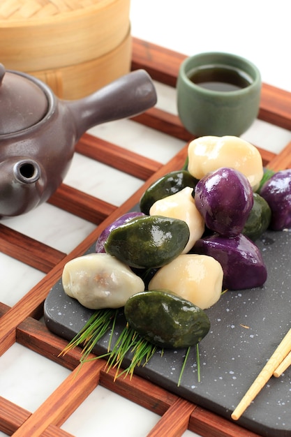 Photo traditional chuseok day food, korean half moon shaped rice cake or songpyeon. made from korean rice flour with sesame seed or chopped nuts, honey, or red bean paste