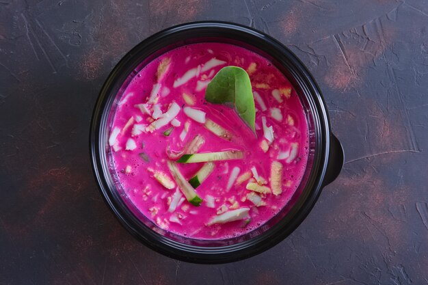 Traditional cold belorussian soup with beef, beetroot, cucumber, radish in take away packaging