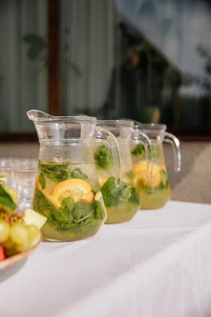 Traditional cool freshly made lemonade and fruits on white table Refreshment summer drink Luxury catering for summer holidays