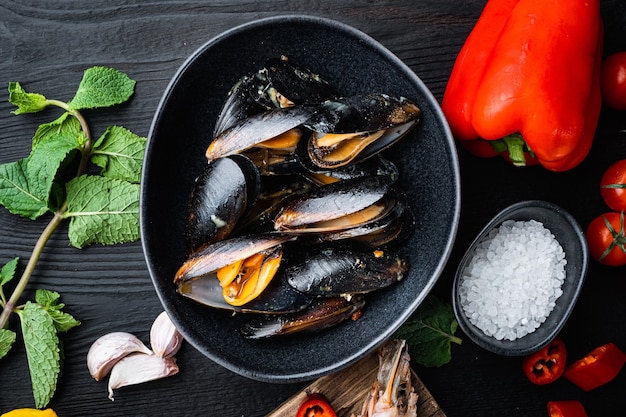 Traditional corsican mussel in bowl on black wooden background, flat lay, food photo