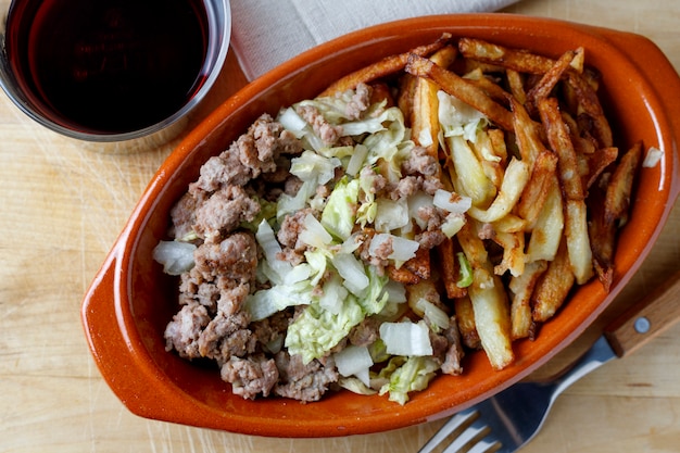 Traditional cuban potatoes with minced meat, lettuce and onion