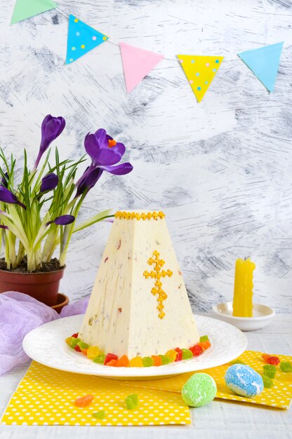 Traditional curd Easter cake with candied fruits and spring flowers crocus on the holiday light background. 