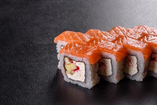 Traditional delicious fresh sushi roll set on a black background