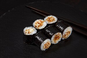 Foto tradizionali deliziosi involtini freschi di sushi con gamberi su sfondo nero rotolo di sushi con crema di riso formaggio avocado salmone sesamo menu sushi ristorante di cucina giapponese