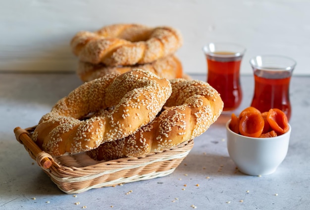 Traditional delicious Turkish food bagel Simit with hot tea and dried apricots