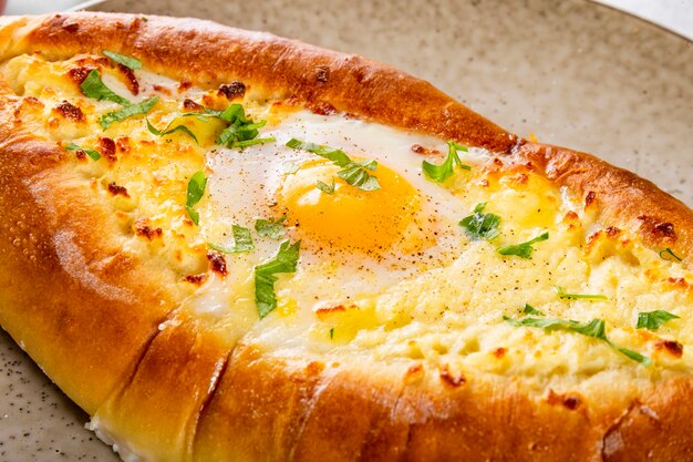 a traditional dish of georgian cuisine adjarian khachapuri with cheese and egg and spicy tomato