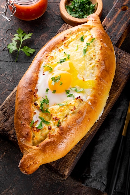 a traditional dish of georgian cuisine adjarian khachapuri with cheese and egg and spicy tomato