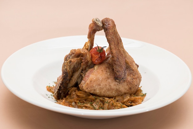 Traditional dish with baked drumstick duck and sour cabbage,  decorated with herbs