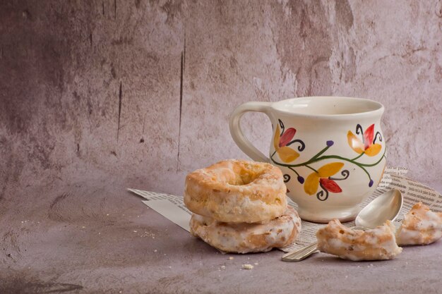 Photo traditional donuts next to a vintage cup with latte