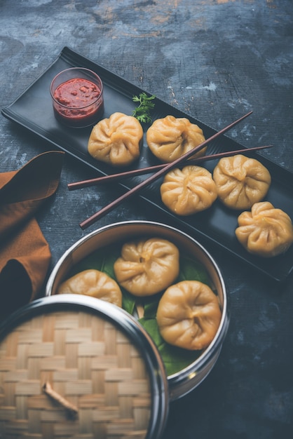 사진 네팔의 전통 만두 모모스 음식은 변덕스러운 배경 위에 토마토 처트니와 함께 제공됩니다. 선택적 초점