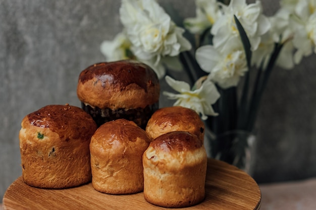 Traditional Easter bun with colored eggs and white flowers on a