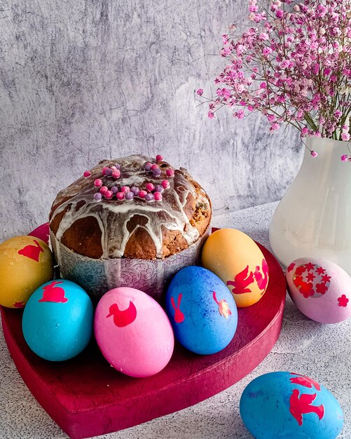 Traditional Easter food of Orthodox Easter cake and colored painted eggs vertical photo grey background