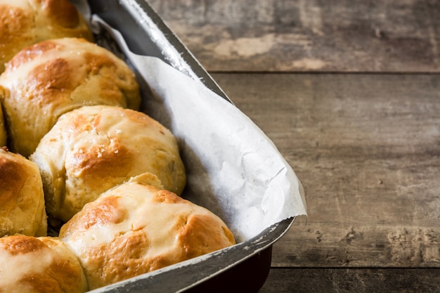 Traditional Easter hot cross buns on wooden table