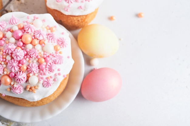 Traditional Easter sweet bread or cakes with white icing and sugar decor colored eggs and cherry blossom tree branch over white table Various Spring Easter cakes Happy Easter day Selective focus