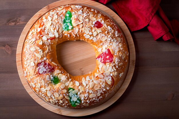 전통적인 주현절 케이크 Roscon de Reyes와 왕관이 나무 탁자 위에 닫혀 있습니다.