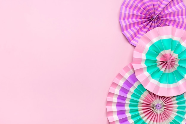 Traditional festival colorful paper fans on pink background with copy space