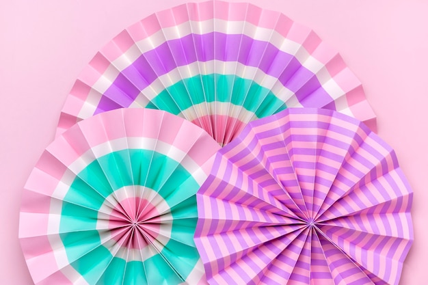 Traditional festival colorful paper fans on pink background