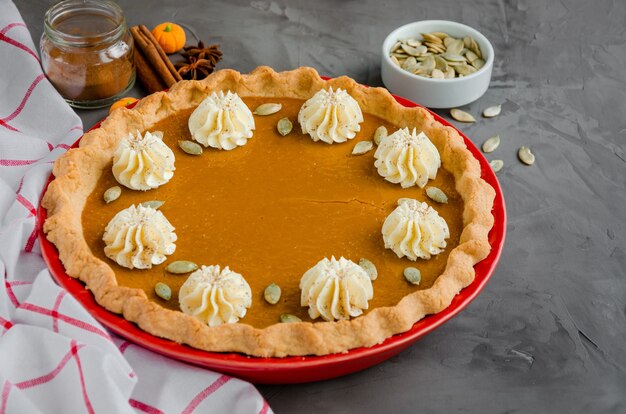 Traditional festive pumpkin pie with spices whipped cream and seeds Dessert for Thanksgiving