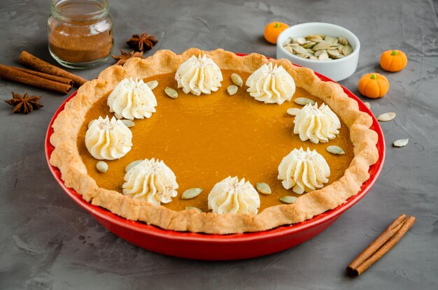 Traditional festive pumpkin pie with spices whipped cream and seeds Dessert for Thanksgiving