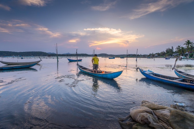 Foto pescatori tradizionali e barche nella laguna di o loan durante il tramonto provincia di phu yen vietnam concetto di viaggio e paesaggio