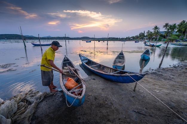 Traditional fishermen and boats in O Loan lagoon during sunset Phu Yen province Vietnam Travel and landscape concept