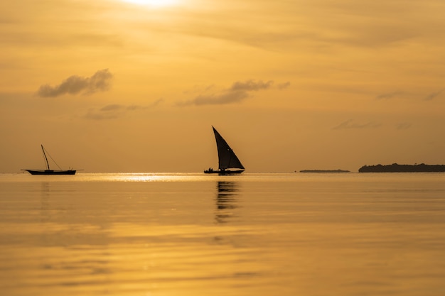 Traditional fishing sailing boat during sunset on Indian ocean in island Zanzibar, Tanzania, Africa