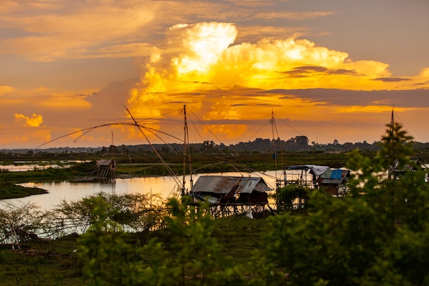 Traditional fishing tool or bamboo fish trap on sunset light, landscape silhouette.