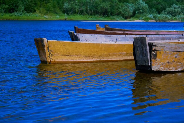 Traditional fishing wooden flat-bottomed boats on the river bank, rural landscape