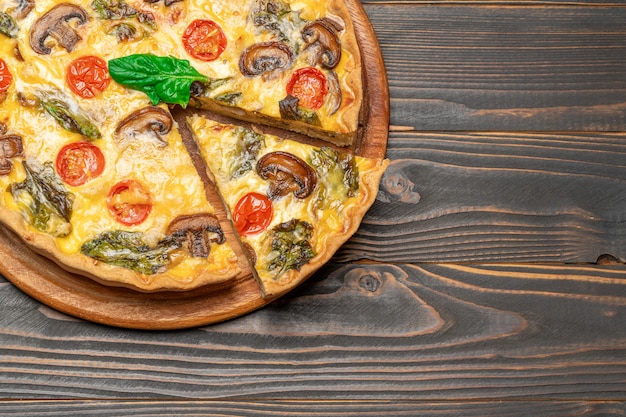 Traditional french Baked homemade quiche pie on wooden board