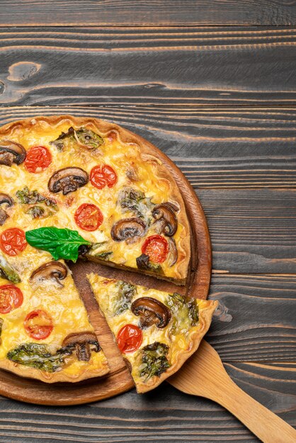 Traditional french Baked homemade quiche pie on wooden board