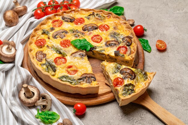 Traditional french Baked homemade quiche pie on wooden cutting board