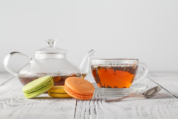 Traditional french colored macarons with cup of tea