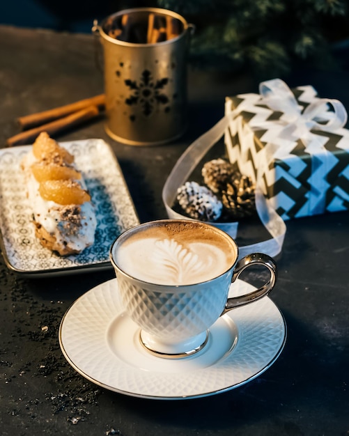 Traditional french dessert eclair composed with a gift box and
coffee shot in a cafe or restaurant gift concept