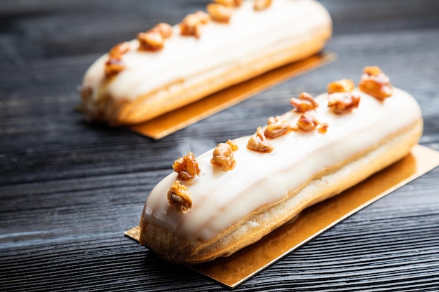 Traditional French dessert. Eclair with white chocolate. Dark background