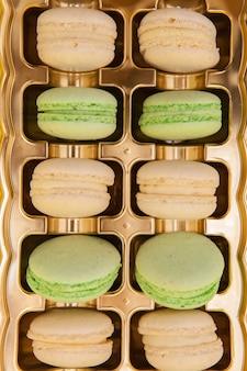 Macarons francesi tradizionali dei dolci in una scatola dorata dolce dolce