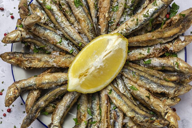 Traditional fried anchovies with lemon and parsley. Seafood concept