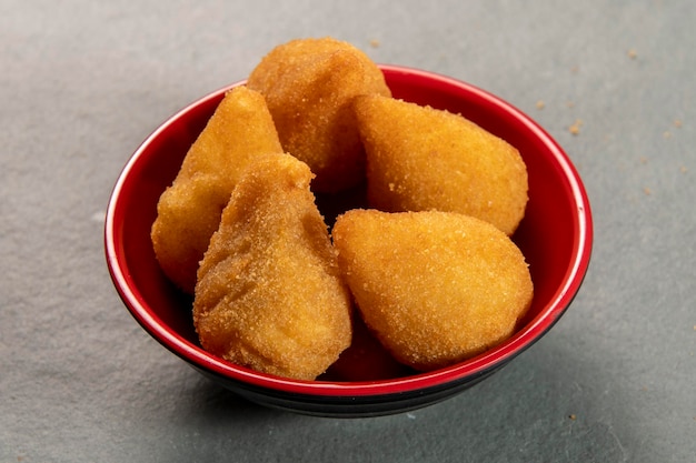 Traditional fried coxinha in plate on slate background popular brazilian snack