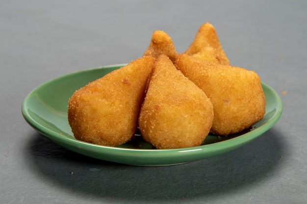 Traditional fried coxinha in plate on slate background popular brazilian snack
