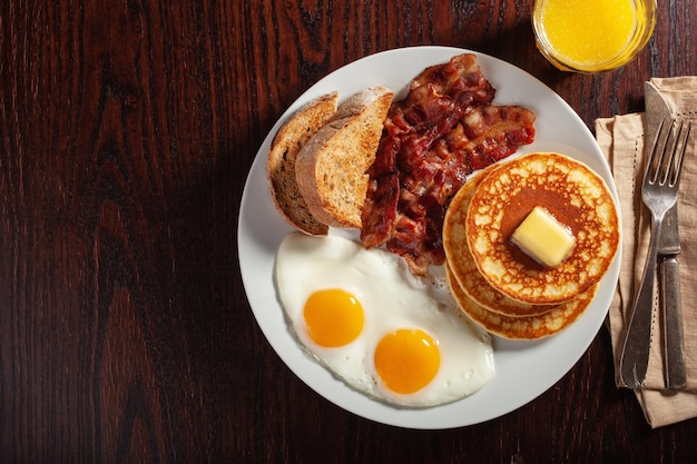 Traditional full american breakfast eggs pancakes with bacon and toast