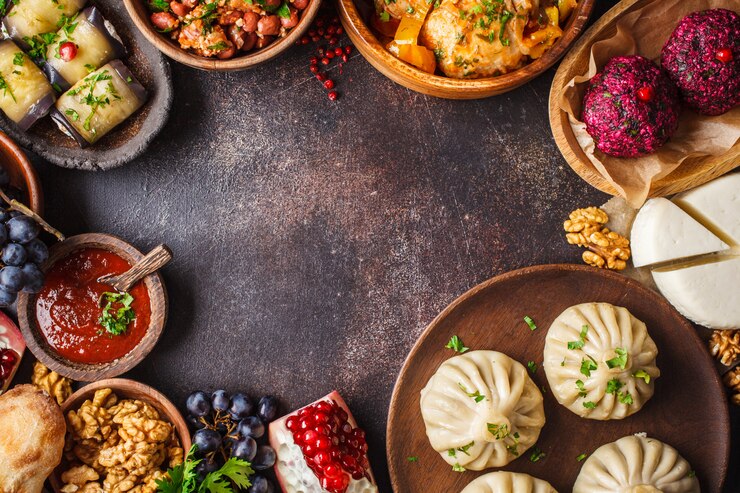 Traditional Georgian cuisine table. Khinkali, phali, chahokhbili, lobio, cheese, eggplant rolls, dark table.