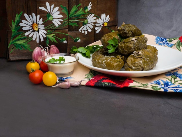 Traditional georgian dolma in grape leaves on rustic wooden table with copyspace