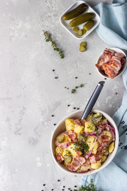 Traditional German potato salad with cucumber, onion and bacon Kartoffelsalat.