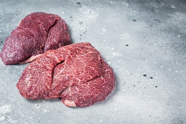 Traditional German raw beef cheeks on butcher table Gray background Top view Copy space