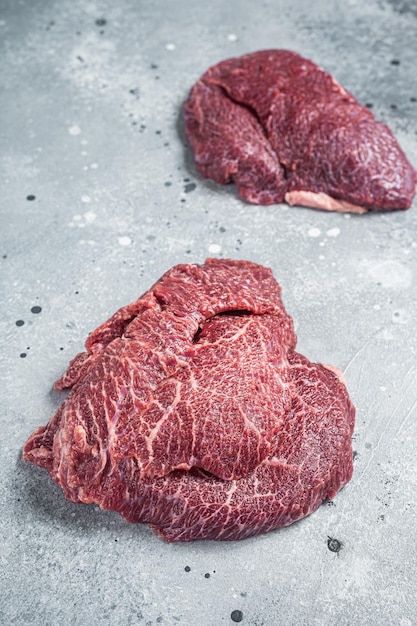 Traditional German raw beef cheeks on butcher table Gray background Top view