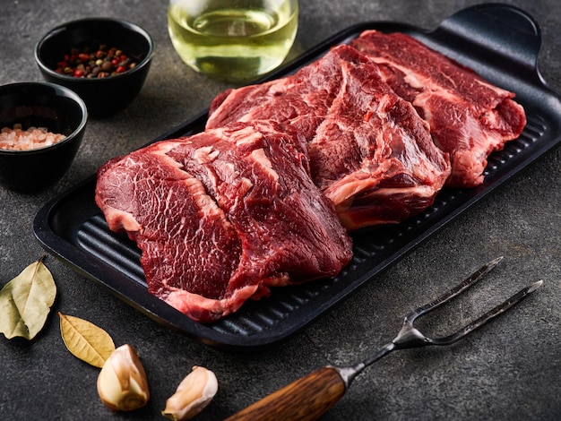 Traditional German raw beef cheeks offered as closeup with herb and spices